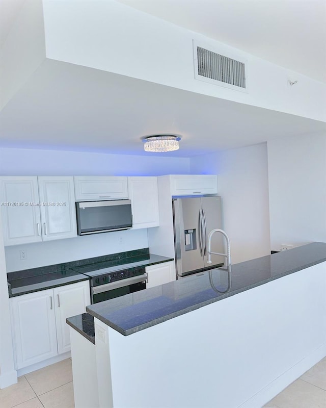 kitchen with stainless steel refrigerator with ice dispenser, sink, light tile patterned floors, white cabinetry, and oven