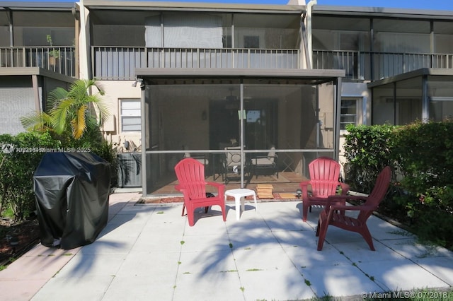 back of property featuring a patio area, a sunroom, and a balcony