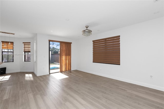 spare room featuring light hardwood / wood-style flooring and plenty of natural light