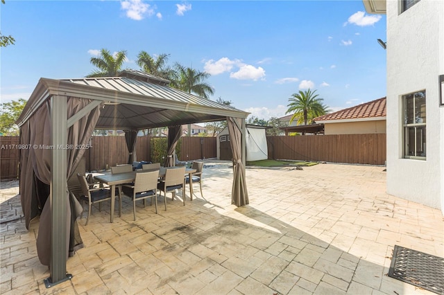 view of patio with a gazebo and a shed