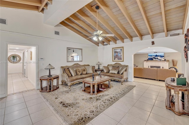 tiled living room featuring wood ceiling, ceiling fan, beam ceiling, high vaulted ceiling, and a fireplace