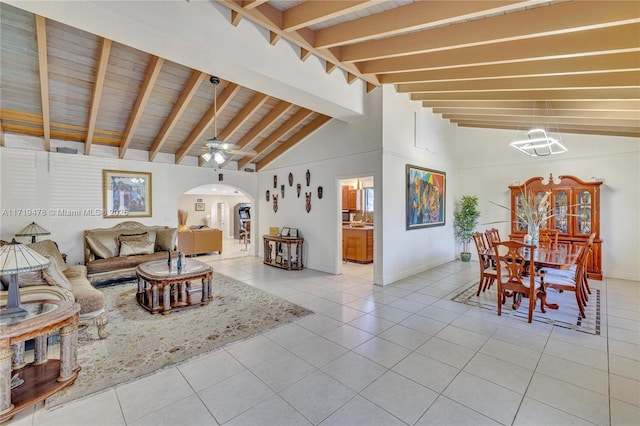 tiled living room featuring ceiling fan with notable chandelier, beam ceiling, and high vaulted ceiling