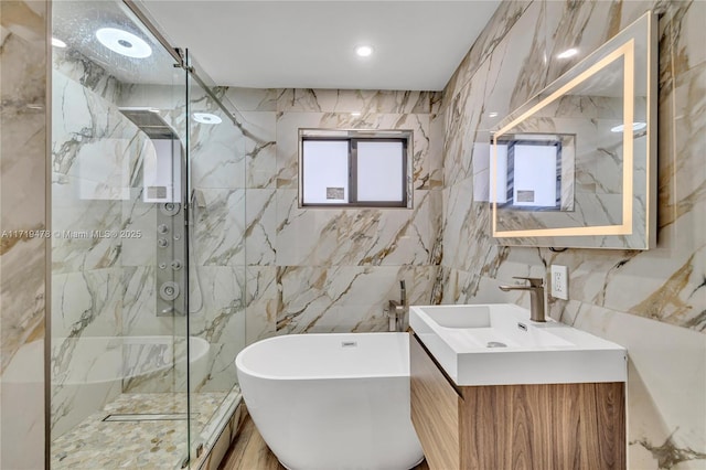 bathroom with vanity, separate shower and tub, and tile walls