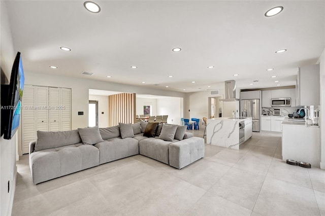 living room featuring sink and light tile patterned floors