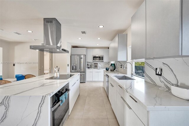 kitchen featuring stainless steel appliances, a spacious island, exhaust hood, sink, and white cabinets