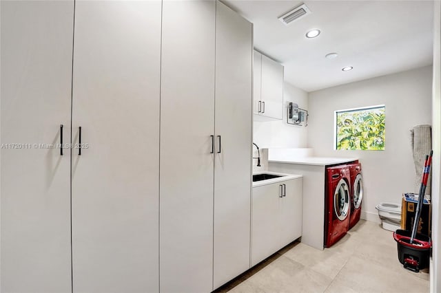 laundry room with washer and dryer, sink, and cabinets