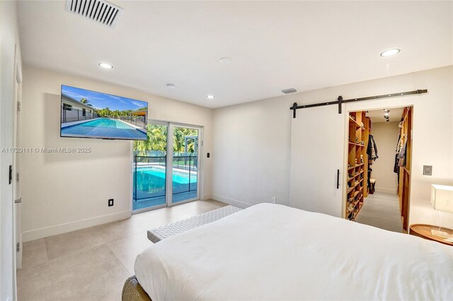 bedroom with access to exterior, a barn door, and a spacious closet