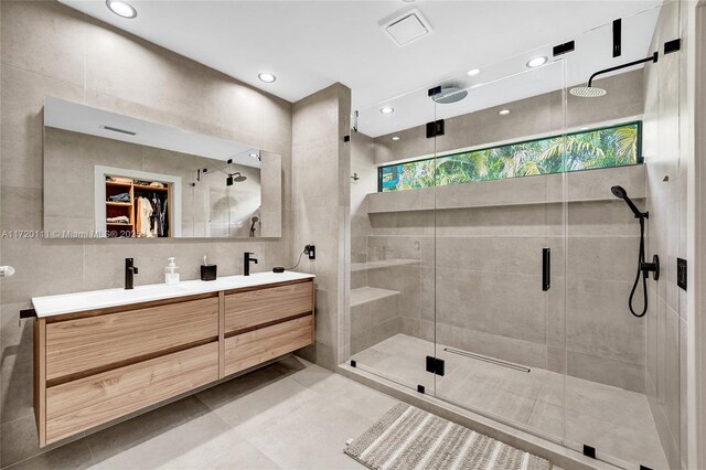 bathroom featuring vanity, an enclosed shower, and tile walls