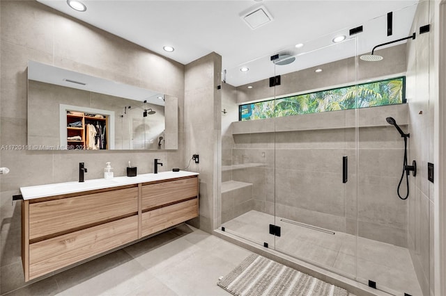 bathroom featuring vanity, an enclosed shower, and tile walls