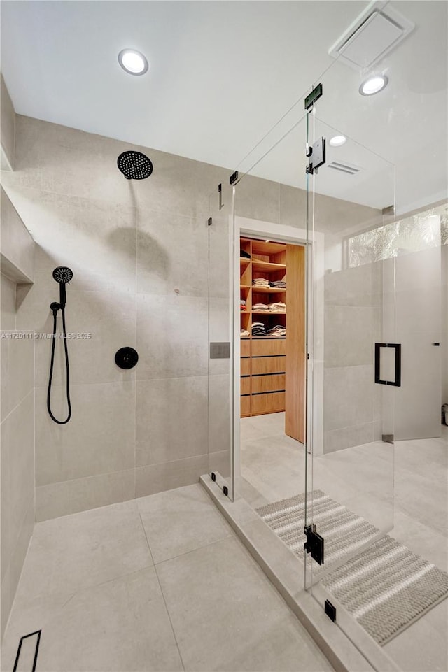 bathroom featuring tile walls and a shower with shower door