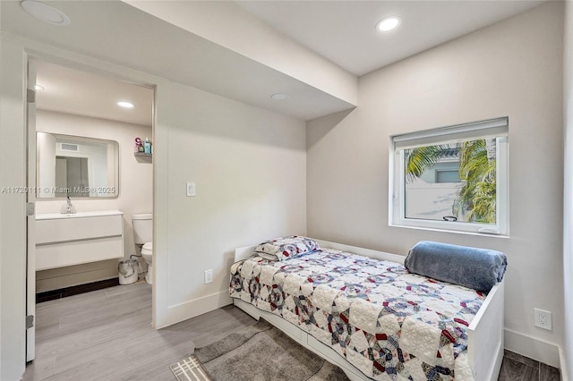 bedroom featuring sink and light wood-type flooring