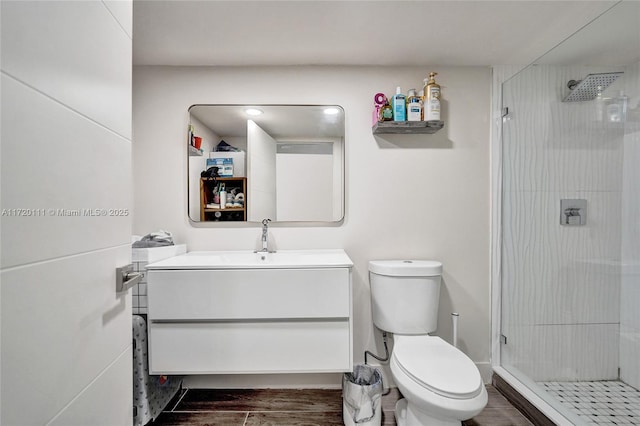 bathroom with a shower with door, vanity, hardwood / wood-style floors, and toilet