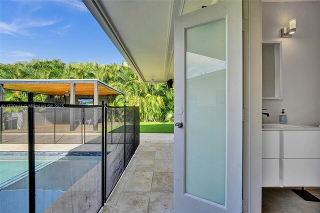 exterior space featuring a fenced in pool and sink