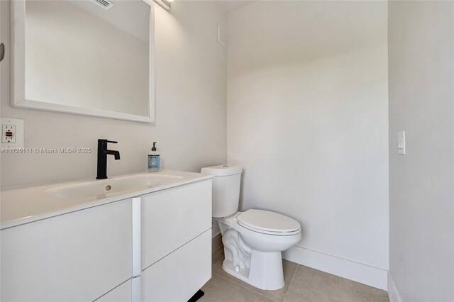 bathroom featuring tile patterned floors, vanity, and toilet