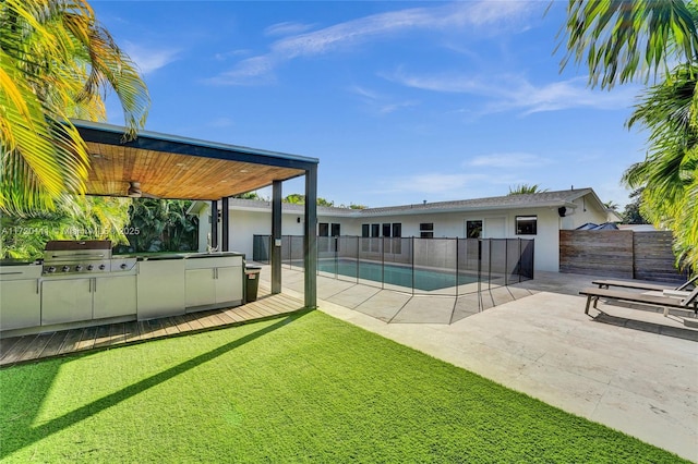 view of pool with a patio, a grill, area for grilling, sink, and a yard