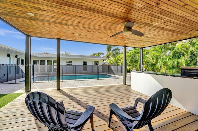 wooden deck with ceiling fan, a fenced in pool, and an outdoor wet bar