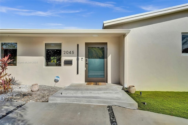 view of exterior entry featuring a yard