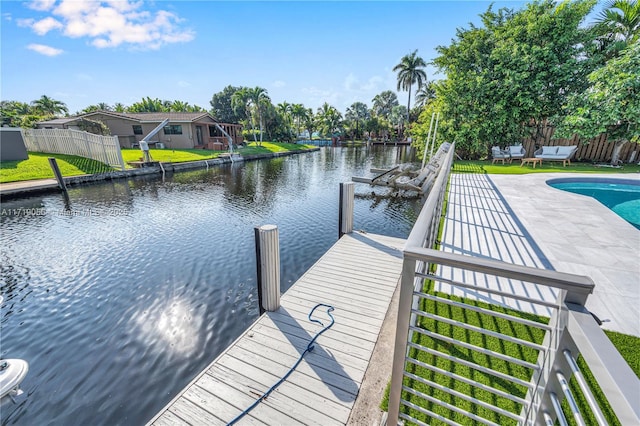 dock area with a water view, a patio area, and a fenced in pool