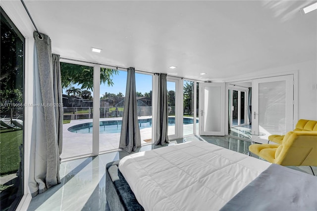 bedroom with floor to ceiling windows and access to exterior