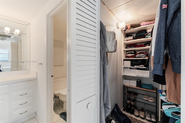 spacious closet with light tile patterned floors