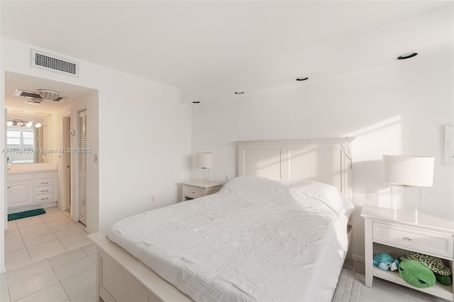 bedroom with light tile patterned flooring and ensuite bath