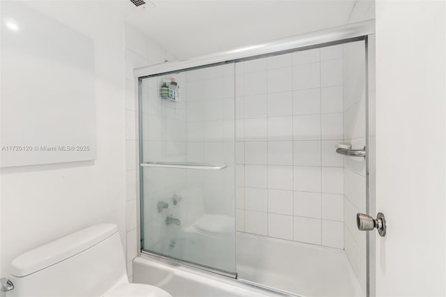 bathroom with shower / bath combination with glass door and toilet