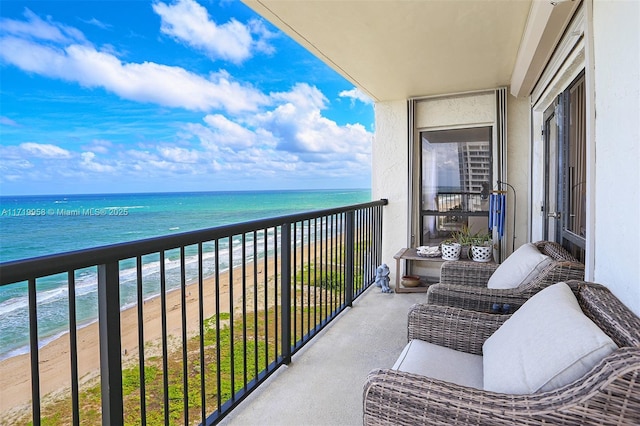 balcony featuring a water view and a beach view