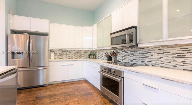 kitchen with stainless steel appliances, tasteful backsplash, dark wood-type flooring, and white cabinets