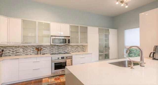 kitchen featuring backsplash, appliances with stainless steel finishes, sink, and white cabinets