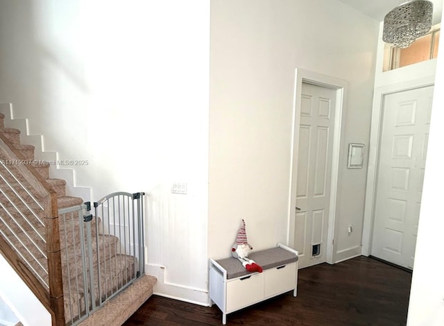 interior space featuring dark wood-style flooring, baseboards, and stairs