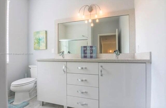 bathroom featuring vanity, toilet, and a shower with shower door