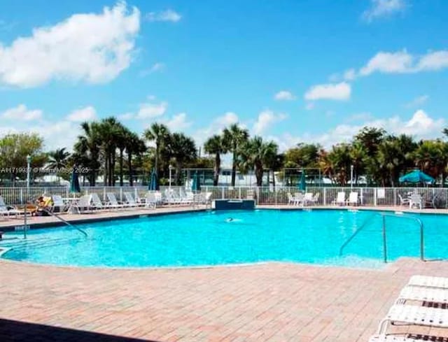 pool with a patio area and fence