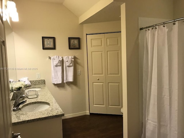 bathroom with a shower with curtain, hardwood / wood-style floors, lofted ceiling, toilet, and vanity