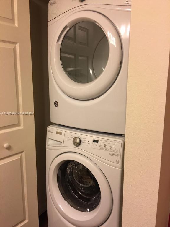 clothes washing area with stacked washer and dryer