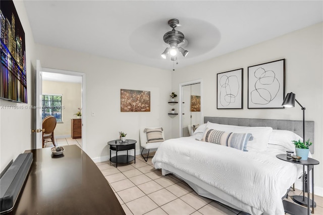 bedroom with ceiling fan, light tile patterned floors, and ensuite bath