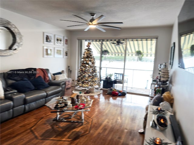 living room with ceiling fan, a textured ceiling, and hardwood / wood-style flooring