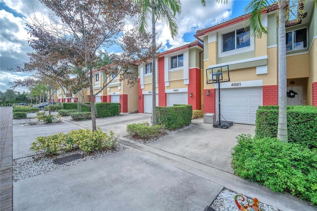 4923 SW 66th Ter Unit 4923, Davie, FL 33314 - view of front of house with a garage, a residential view, driveway, brick siding, and stucco siding