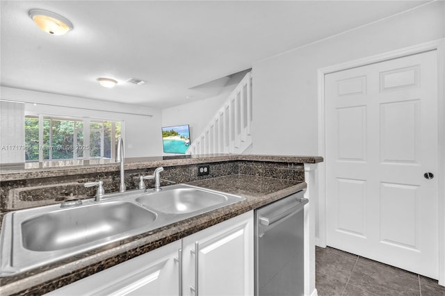 kitchen with white cabinetry, dishwasher, sink, and dark tile patterned floors