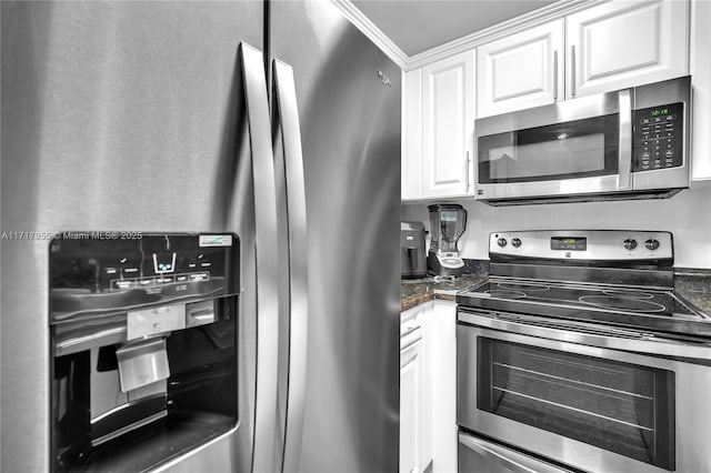 kitchen featuring stainless steel appliances, dark stone countertops, and white cabinets