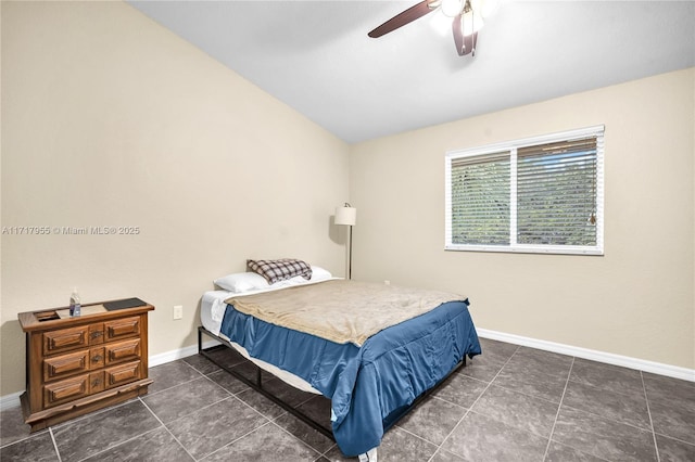 bedroom with vaulted ceiling, ceiling fan, dark tile patterned floors, and baseboards