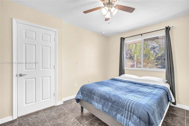 bedroom featuring ceiling fan and dark tile patterned floors