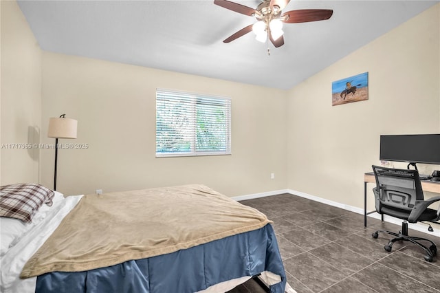 bedroom with lofted ceiling, ceiling fan, dark tile patterned flooring, and baseboards