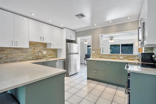 kitchen with light countertops, visible vents, appliances with stainless steel finishes, white cabinets, and green cabinetry