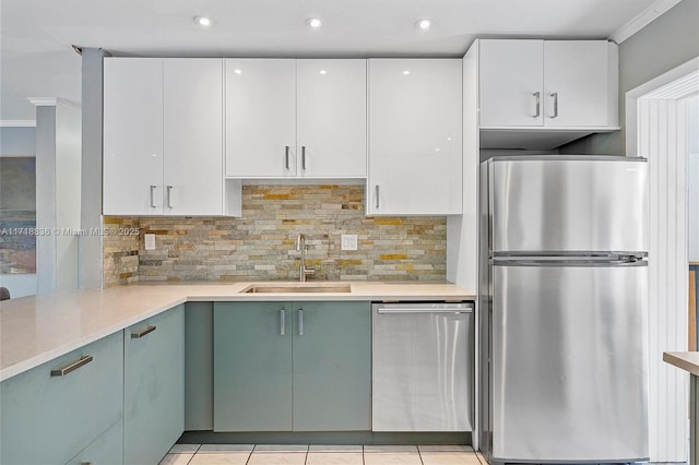 kitchen with white cabinetry, appliances with stainless steel finishes, light countertops, and a sink