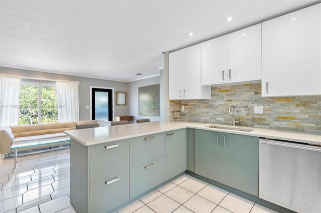 kitchen with open floor plan, white cabinets, a sink, dishwasher, and a peninsula