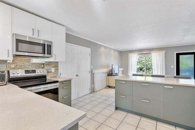 kitchen featuring crown molding, stainless steel appliances, light countertops, open floor plan, and white cabinets