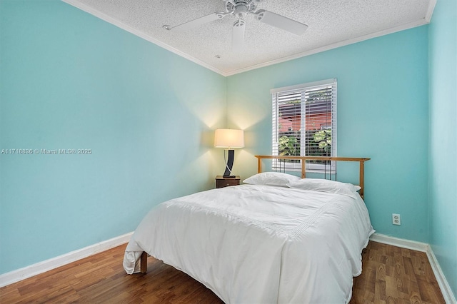 bedroom featuring crown molding, baseboards, and wood finished floors