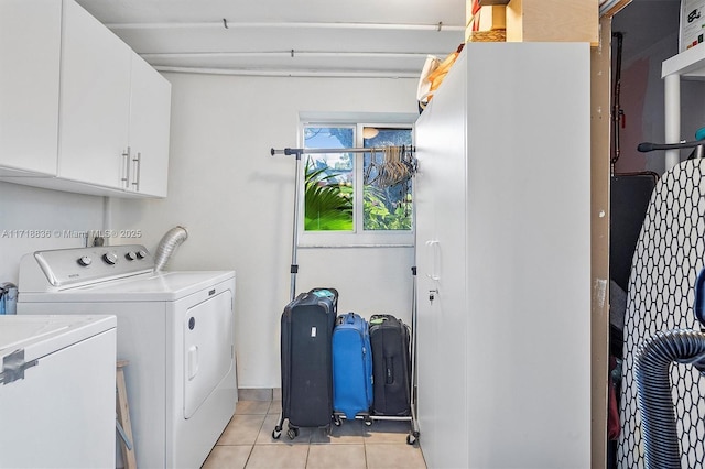 laundry room with light tile patterned floors, separate washer and dryer, and cabinet space