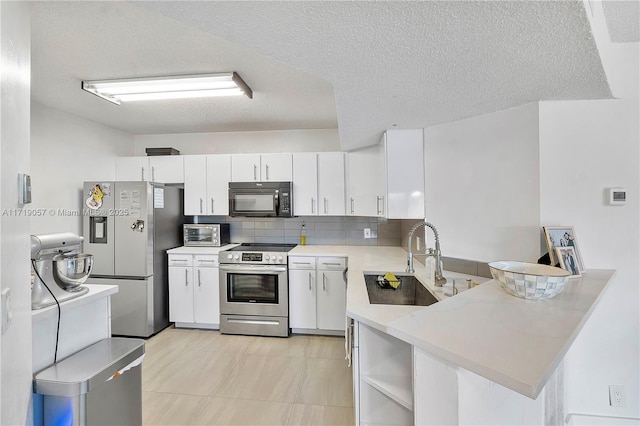 kitchen featuring kitchen peninsula, sink, white cabinetry, and stainless steel appliances