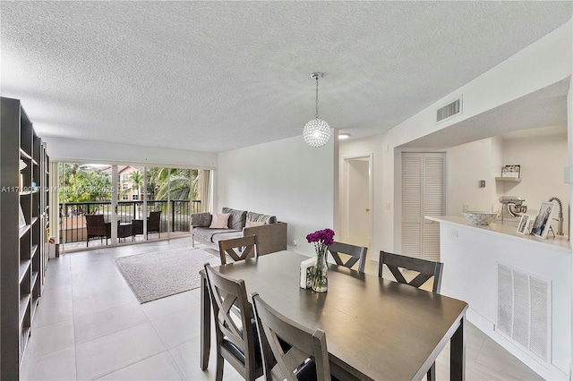 dining area featuring light tile patterned floors and a textured ceiling